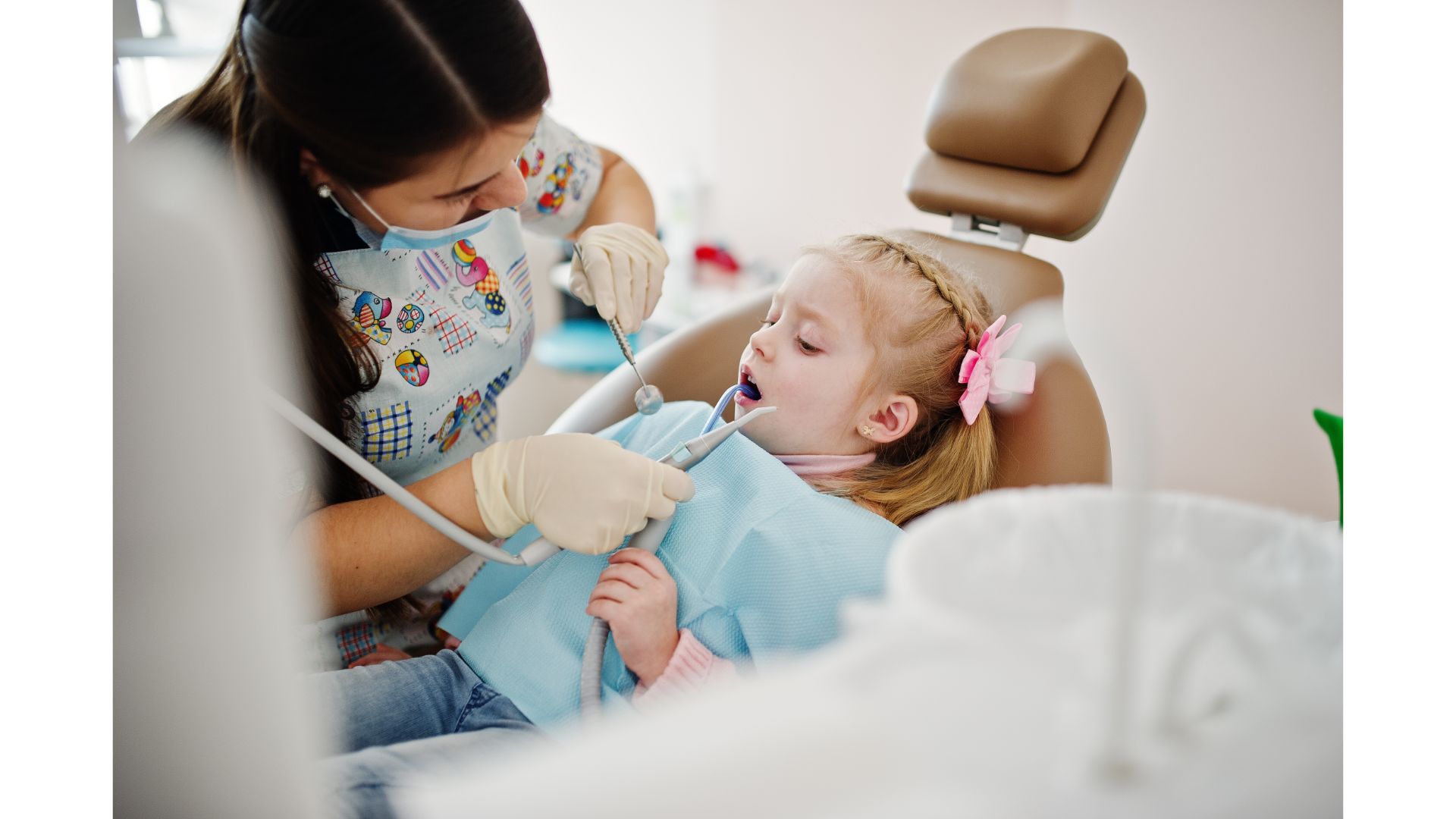A dental professional examines a young child.